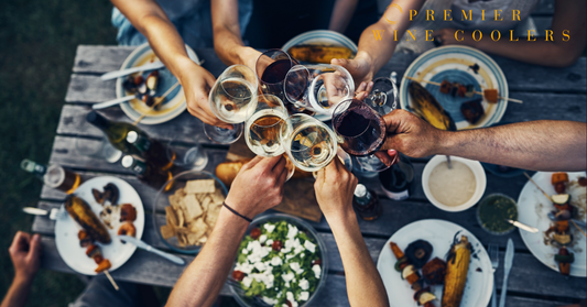 people cheering over rustic picnic table with delicious food and wine