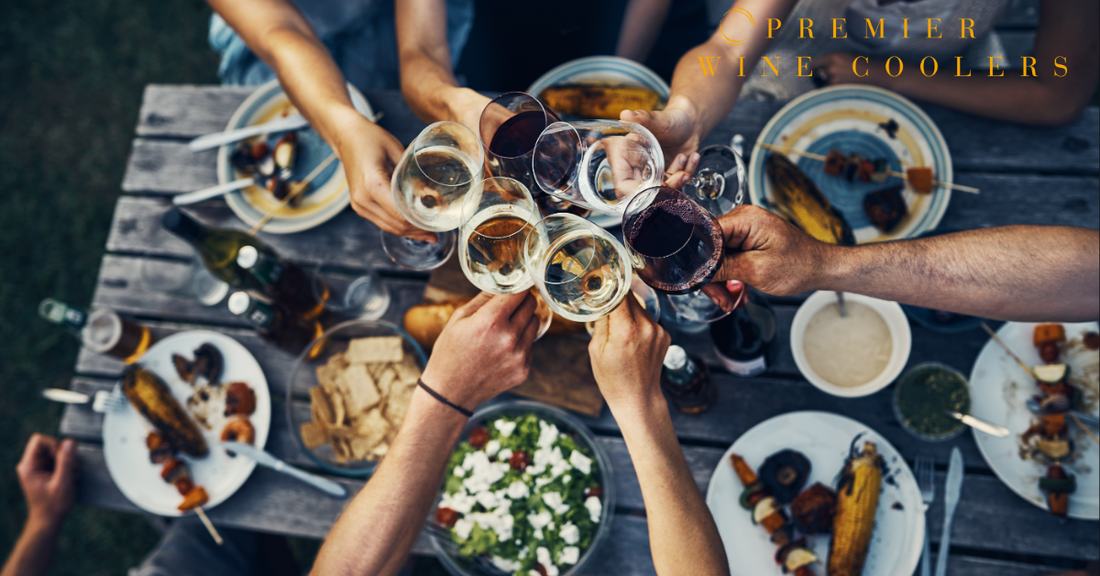 people cheering over rustic picnic table with delicious food and wine