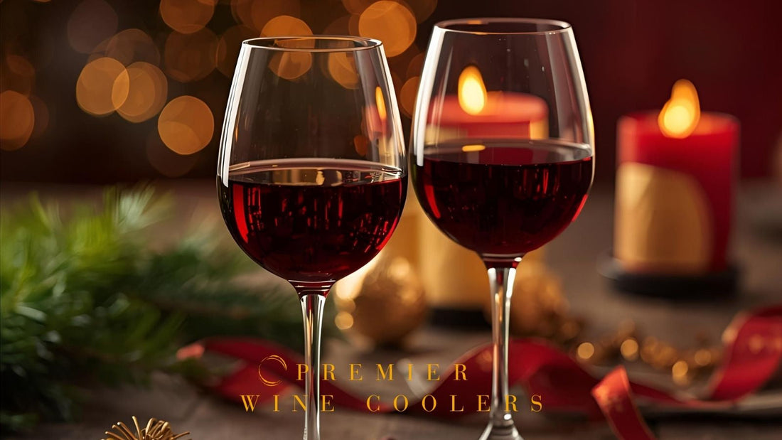 2 glass of red wine sitting on wood table with warm lighting, candels, red ribbon and pine needles for festive feeling