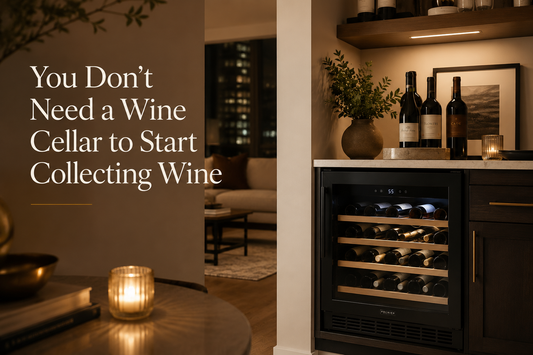 Warm modern apartment home bar featuring a compact built-in wine fridge stocked with wine bottles, soft evening lighting, dark wood cabinetry, and curated wine decor beside the text “You Don’t Need a Wine Cellar to Start Collecting Wine.”